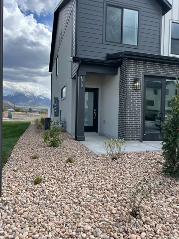 Contemporary exterior featuring dark grey horizontal siding, light grey stucco, and dark brick accents