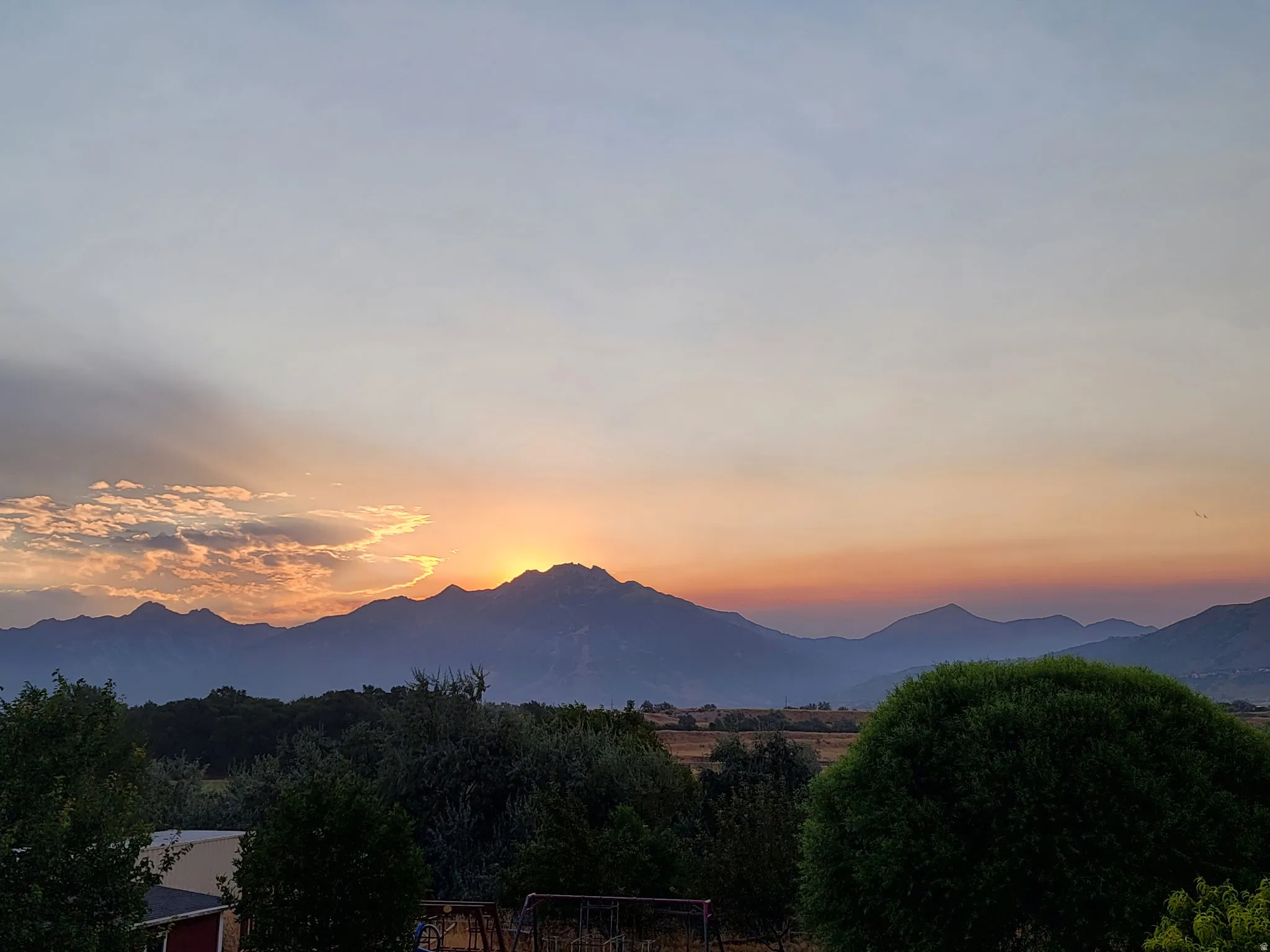 Expansive mountain range backdrop with a dramatic evening sky