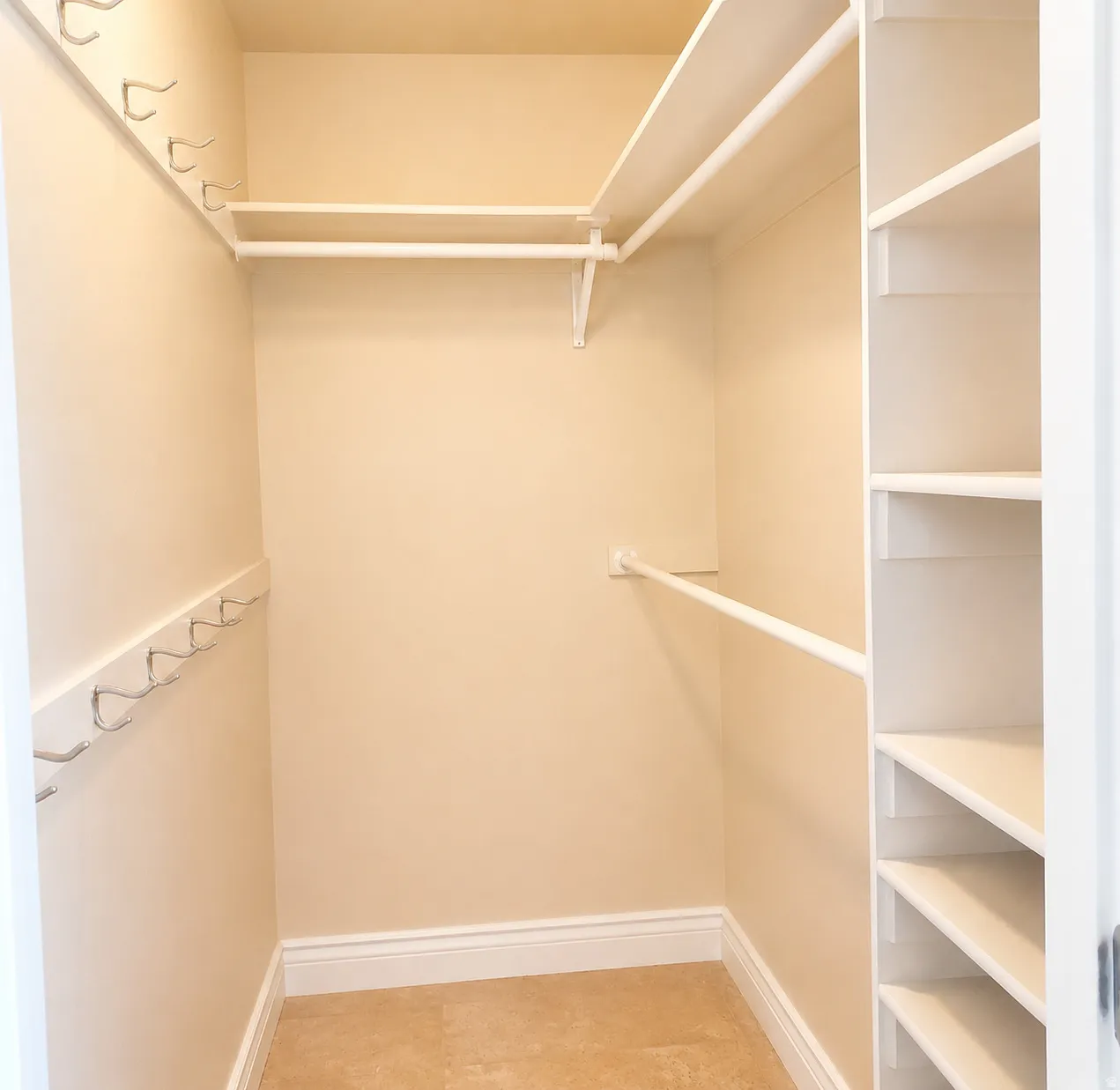 ADU #2 - Walk-in closet featuring built-in shelving, multiple hanging rods, and wall-mounted hooks