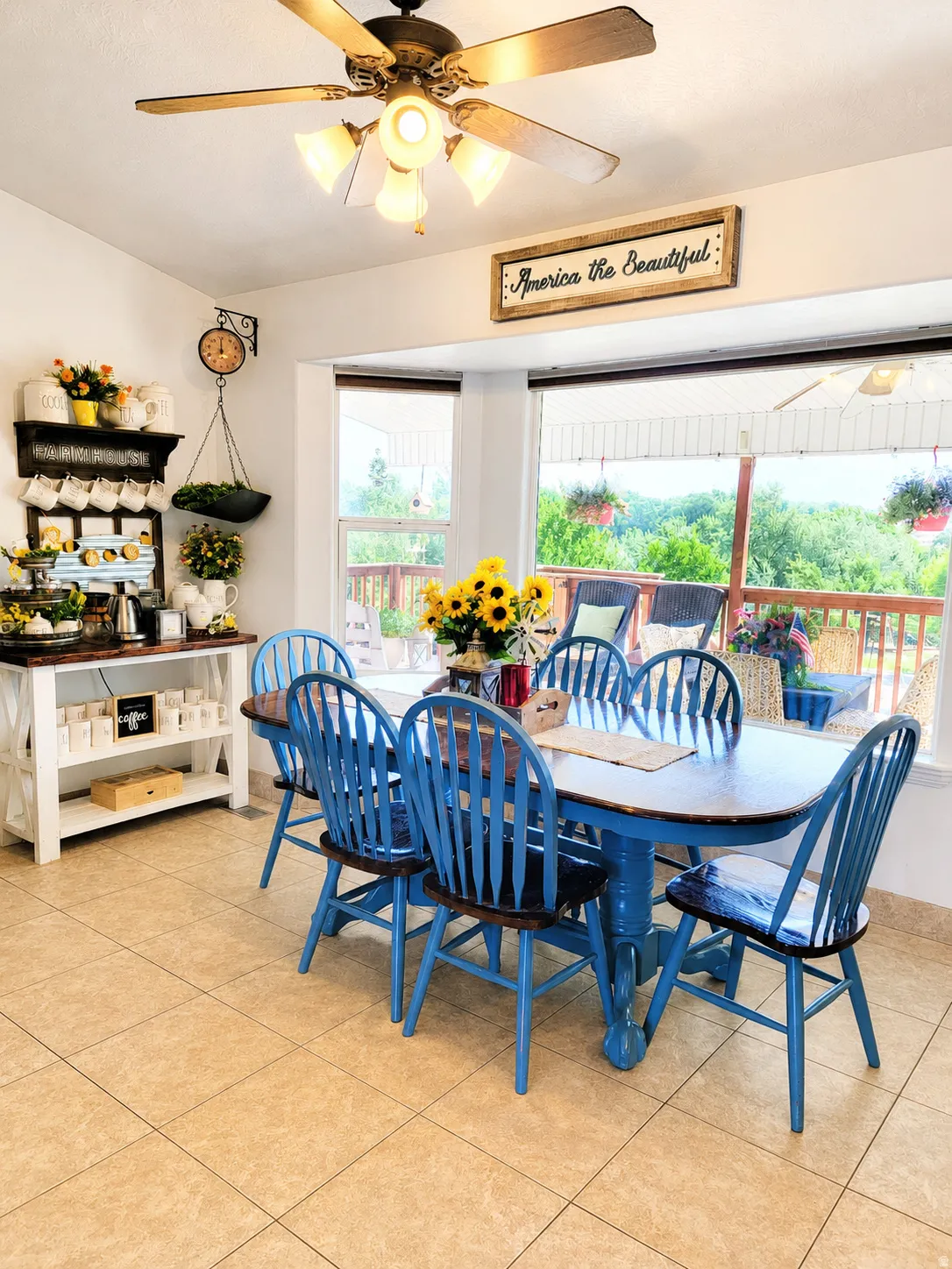 Dining area featuring a bay window with expansive outdoor views, ceramic tile flooring, and a ceiling fan with integrated lighting