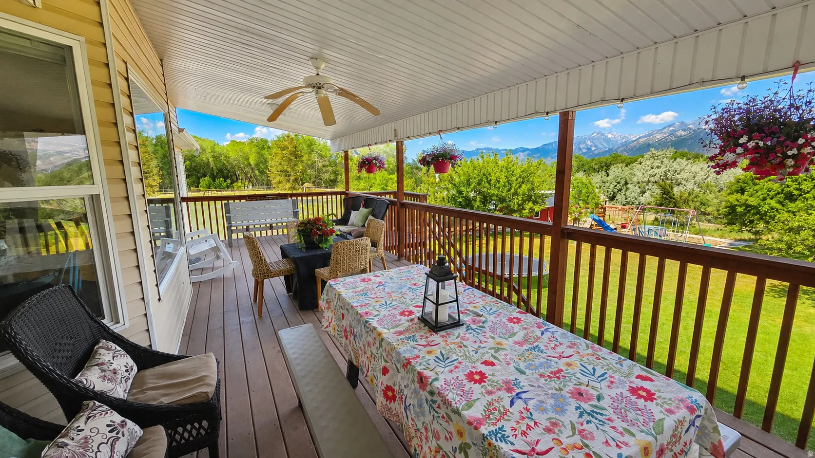 Expansive covered deck featuring a ceiling fan, wood-finish flooring, and a railing system