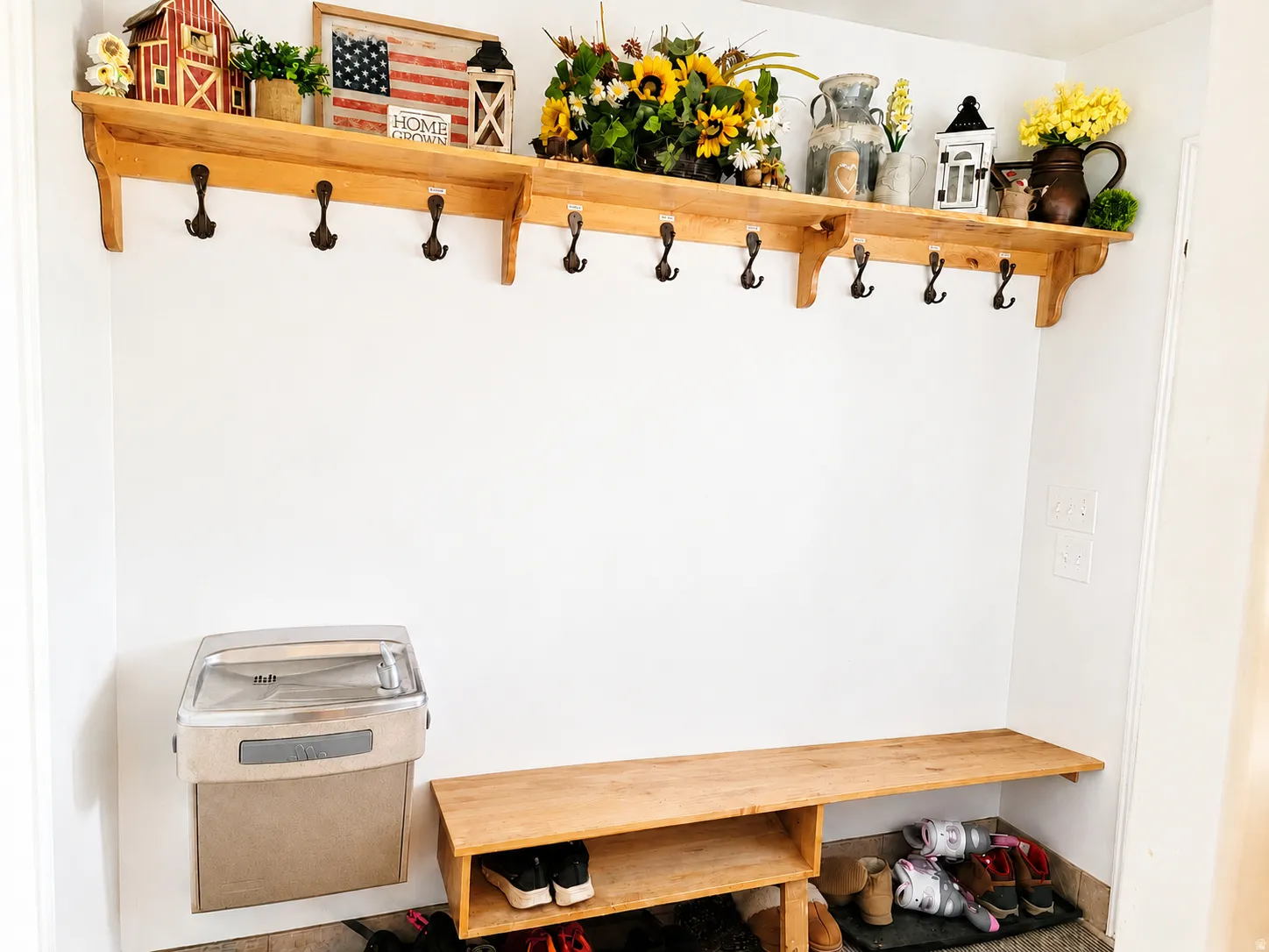 Built-in wood-finish shelving with multiple hooks