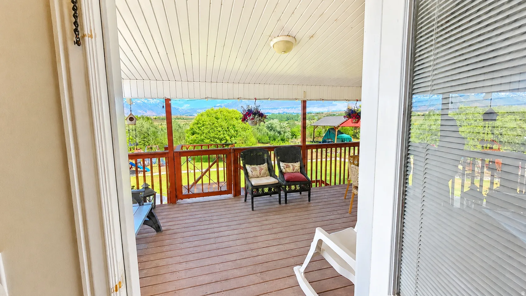 Expansive covered deck featuring wood-finish flooring and a wood railing
