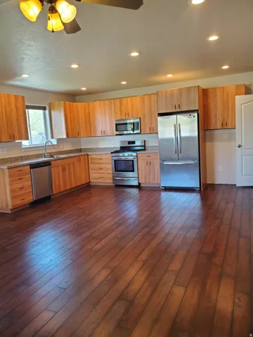Spacious kitchen featuring extensive wood-finish cabinetry and dark wood-finish flooring