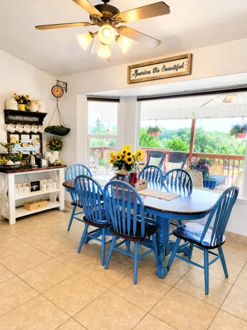 Dining area featuring a bay window with expansive outdoor views, ceramic tile flooring, and a ceiling fan with integrated lighting