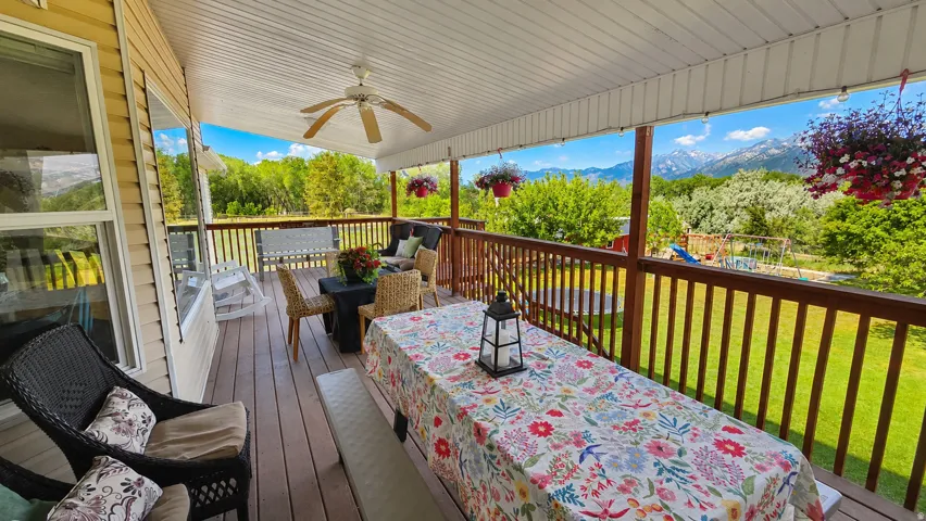 Expansive covered deck featuring a ceiling fan, wood-finish flooring, and a railing system