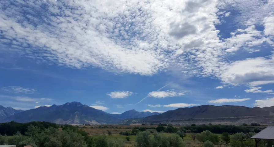Expansive mountain range backdrop with a vast blue sky overhead