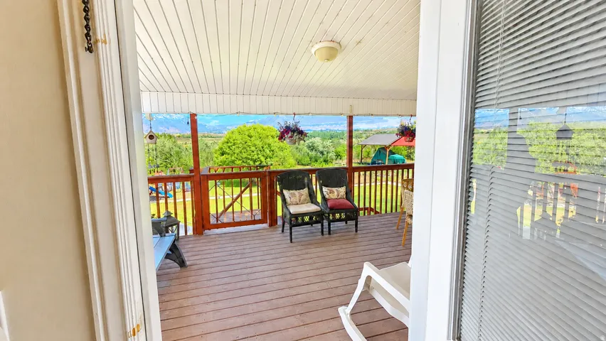 Expansive covered deck featuring wood-finish flooring and a wood railing