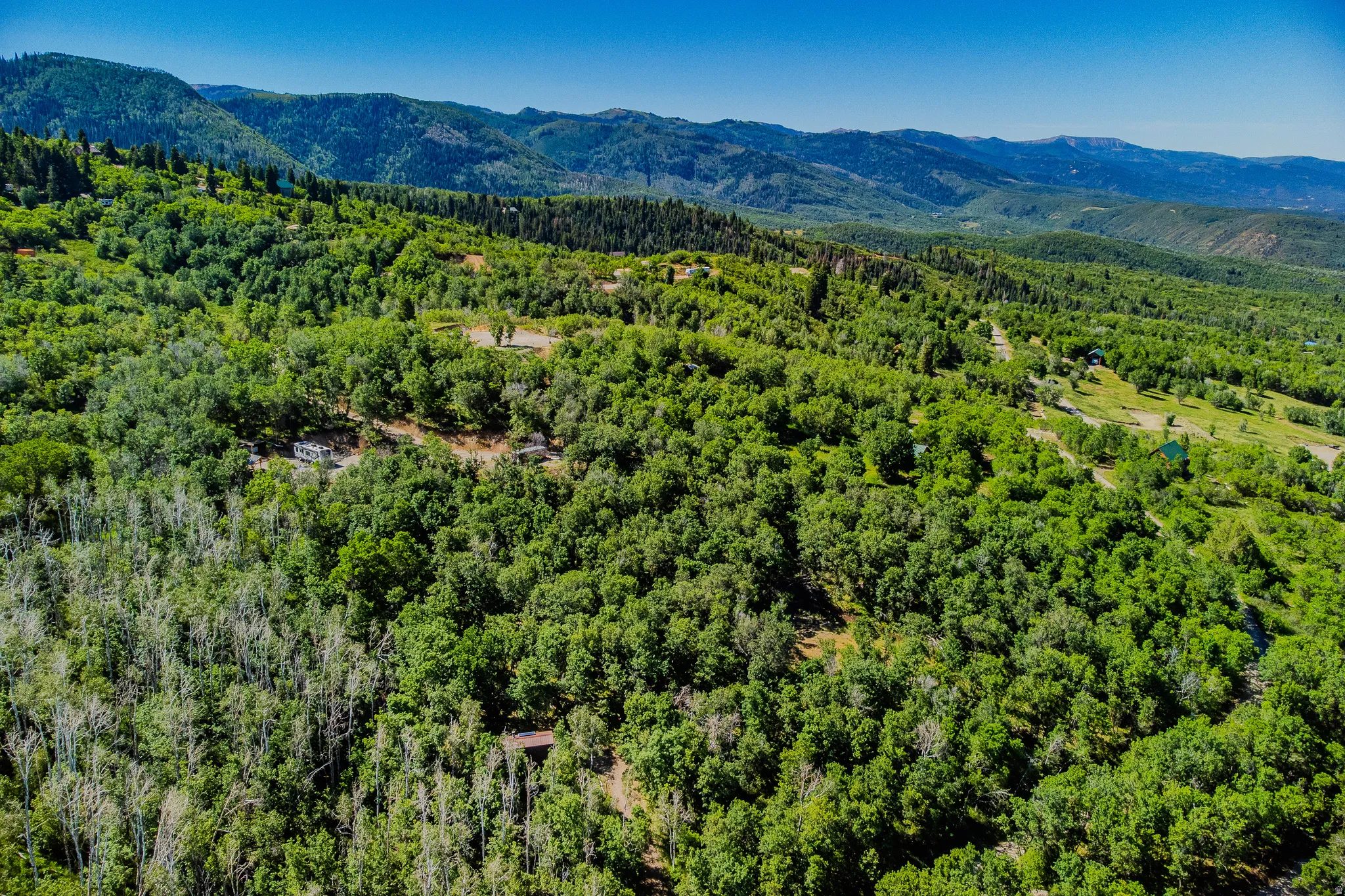 Expansive forested landscape with distant mountain ranges under a clear sky