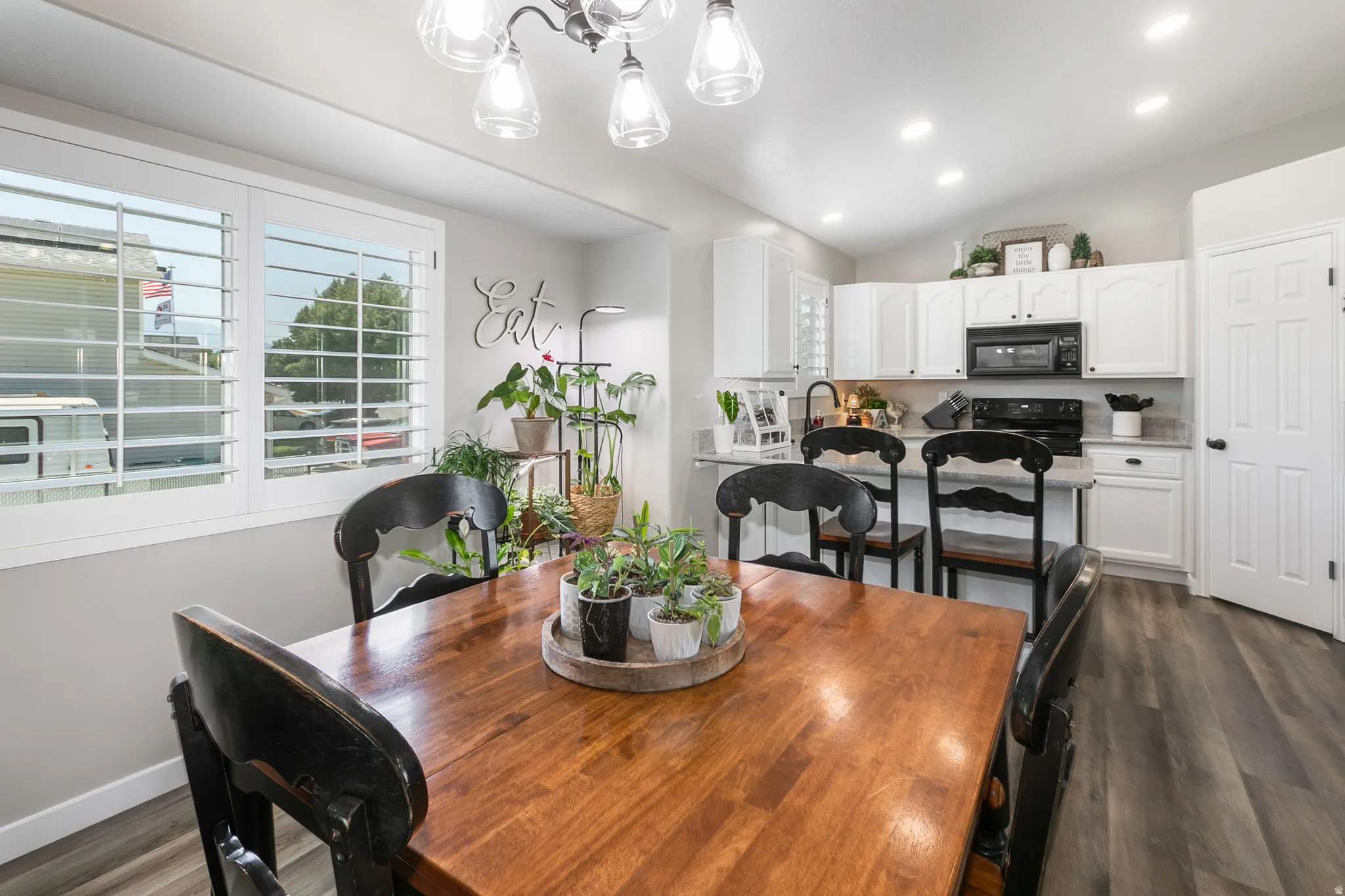 Dining area featuring a wood-finish table, plantation shutters, and recessed lighting
