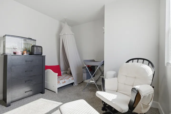 Bright interior room featuring light gray carpeting and white painted walls