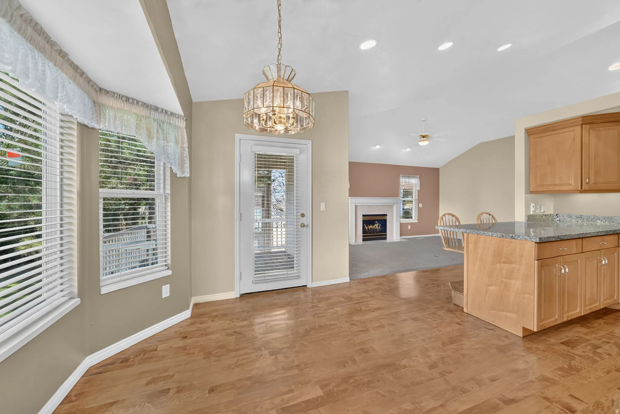 Kitchen with wood-finish flooring, light wood cabinetry, and granite countertops