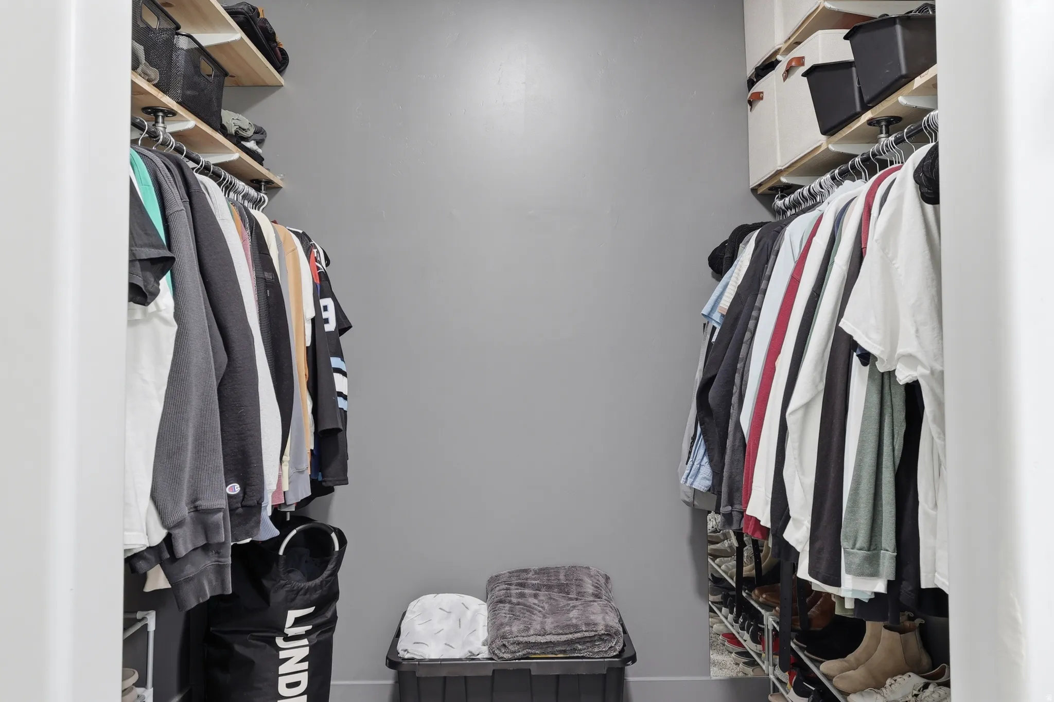 Closet featuring dual-sided hanging rods and overhead shelving