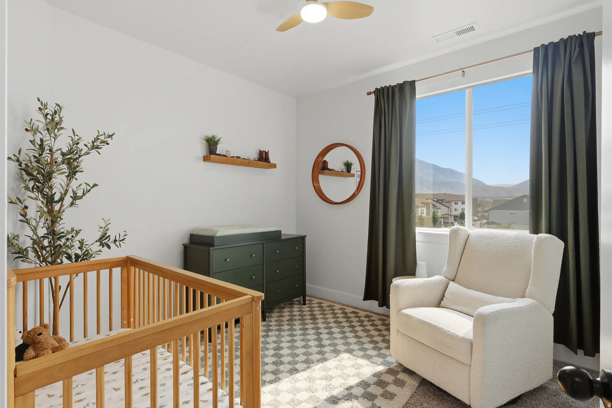 Bright interior space with a large window, mountain backdrop, and a ceiling fan