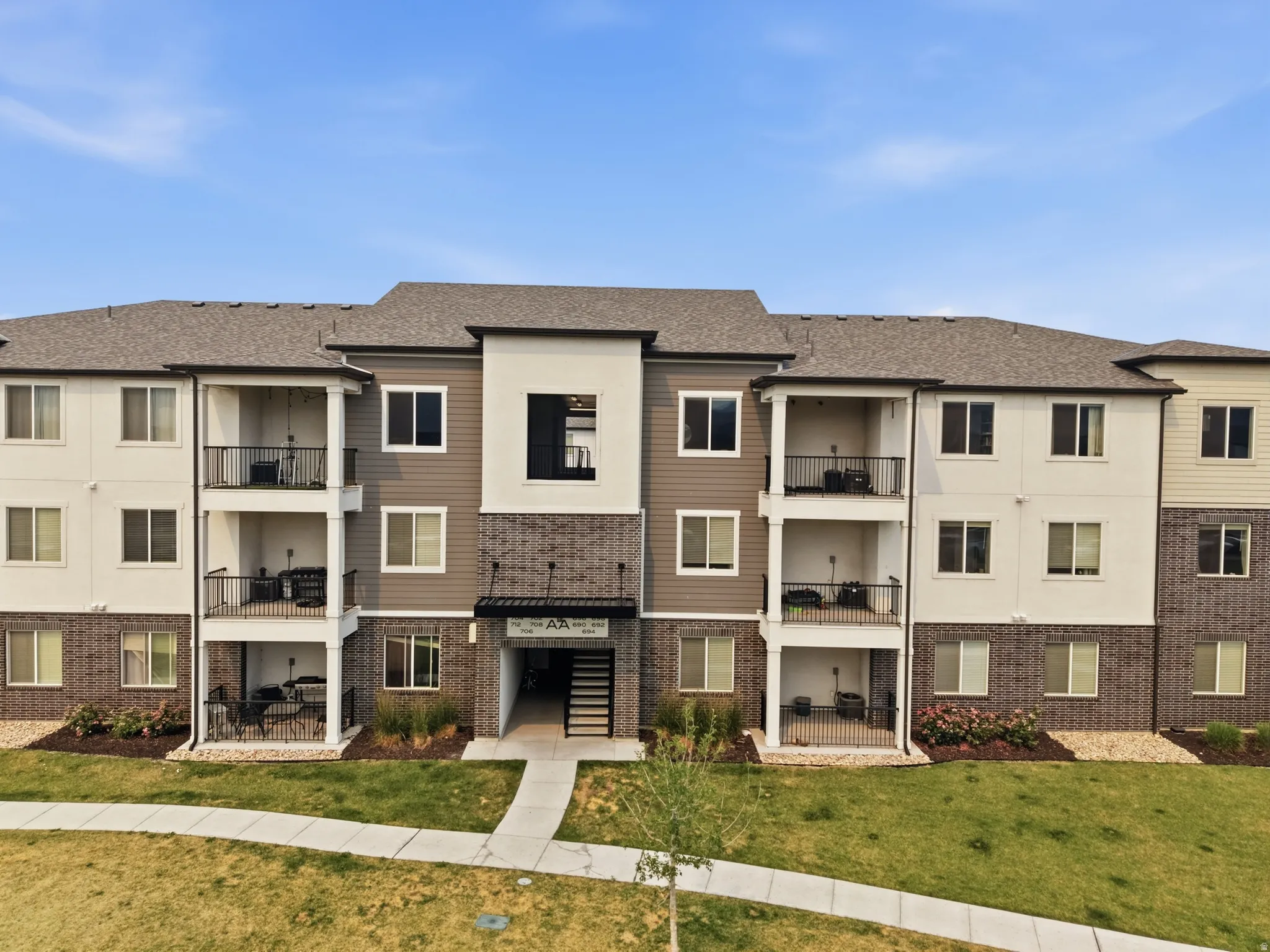 Contemporary multi-story building featuring a blend of neutral-toned siding and brick accents