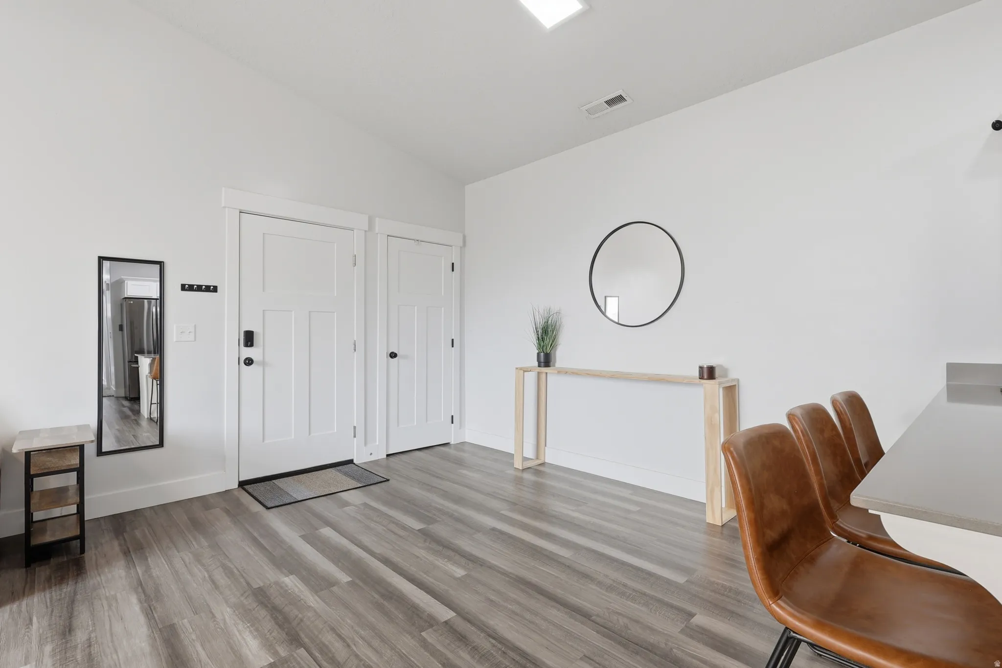 Entryway featuring wood-finish flooring, crisp white walls, and a recessed ceiling light