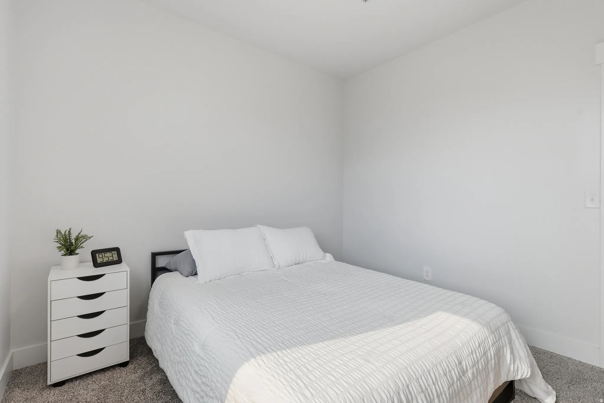 Carpeted room with light neutral walls and white baseboards