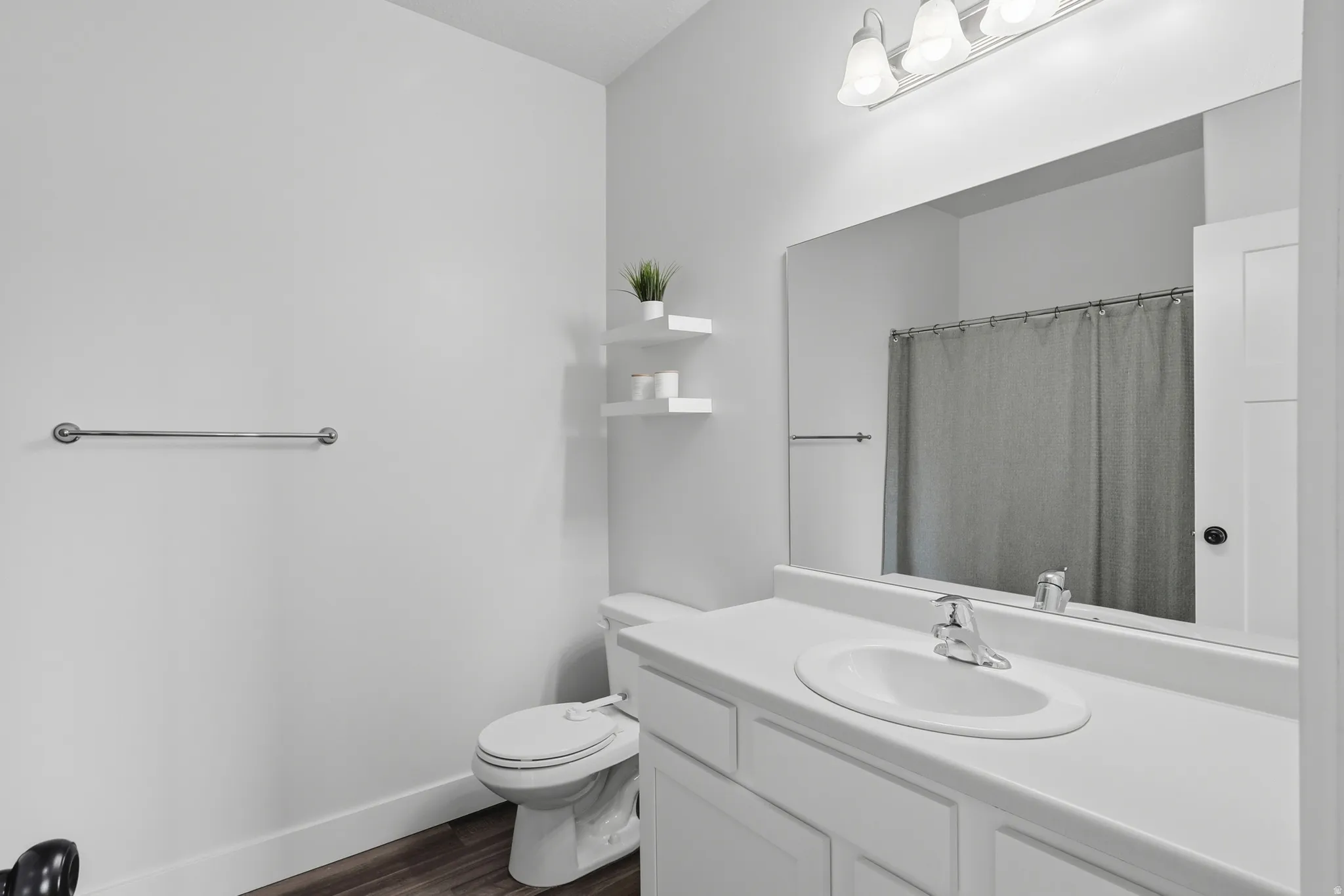 Bathroom featuring a white vanity with an integrated sink, chrome faucet, and a large wall-mounted mirror