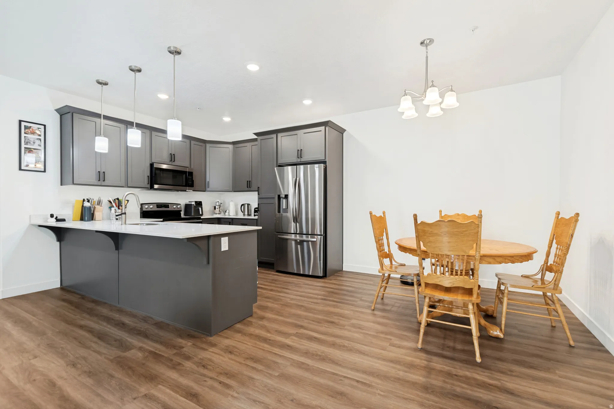 Open-concept kitchen and dining area with wood-finish flooring