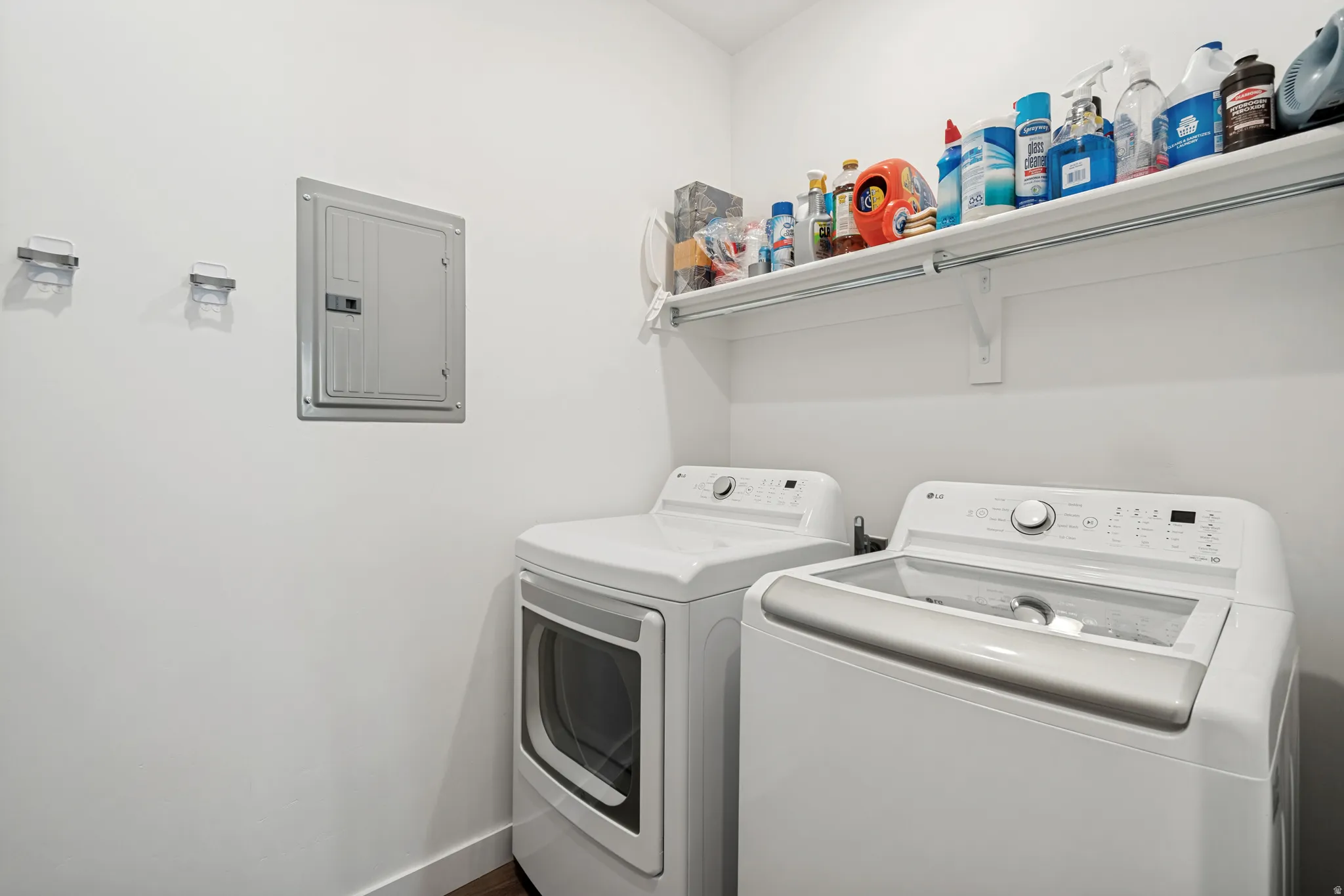 Dedicated laundry area featuring a built-in shelf for storage