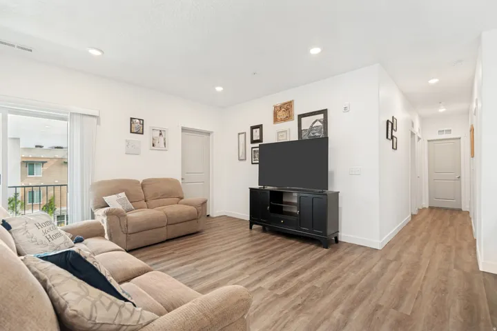 Spacious living area featuring wood-finish flooring, white walls, and recessed lighting