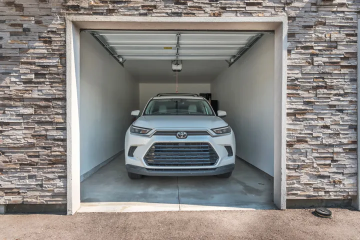 Single-bay garage featuring an automatic door opener, finished interior walls, and a concrete floor