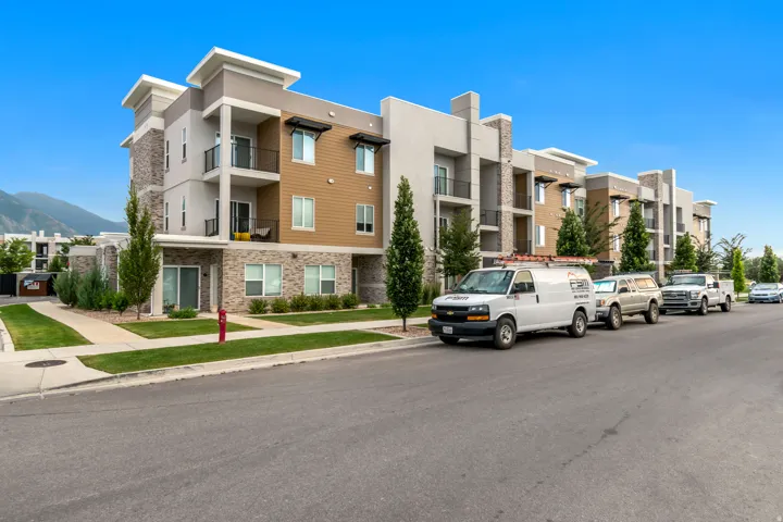 Multi-story building featuring modern architecture with balconies and integrated stone facade accents