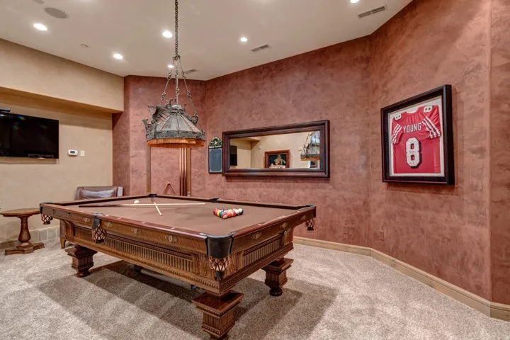 Recreation room featuring an ornate billiards table with a detailed wood frame, upholstered felt playing surface, and integrated ball pockets