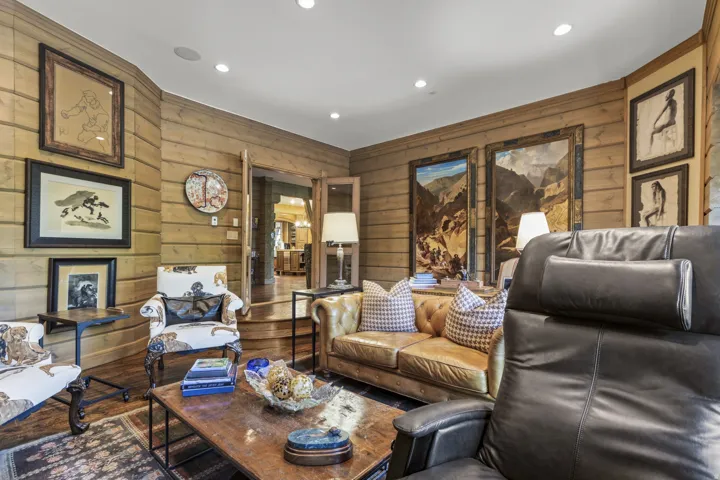 Living area featuring horizontal wood paneling, recessed lighting, and wood-finish flooring