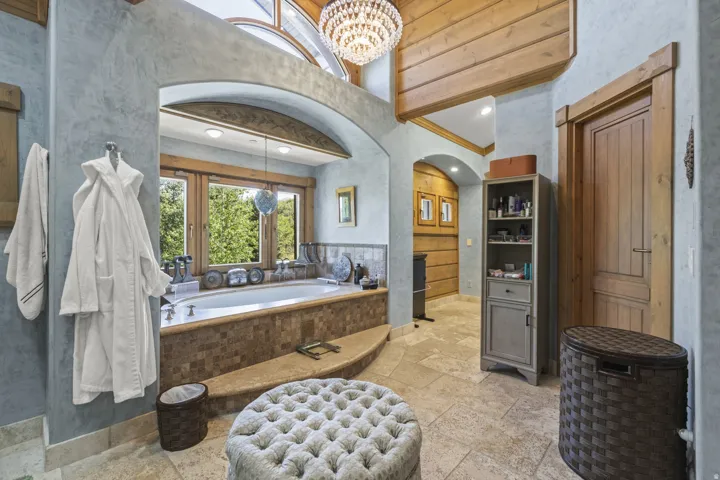 Soaking tub with mosaic tile surround and expansive window