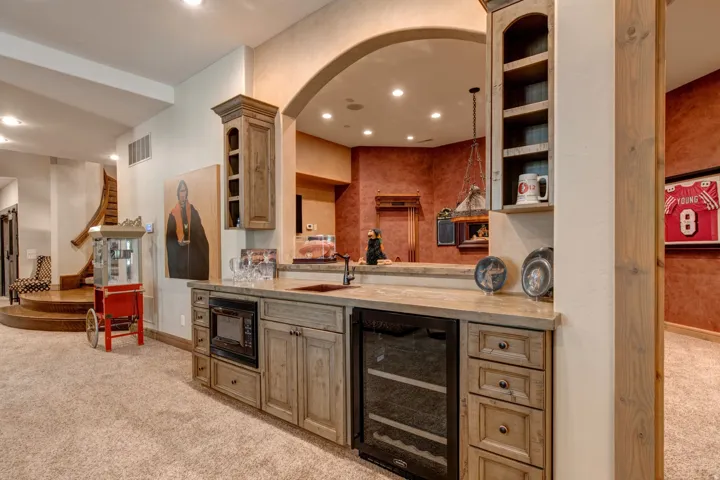 Custom wet bar featuring a built-in microwave, beverage cooler, and integrated sink