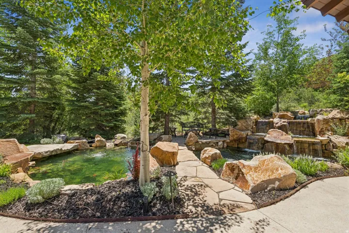 Expansive outdoor water feature showcasing multiple cascading waterfalls, a tranquil pond, and natural stone landscaping