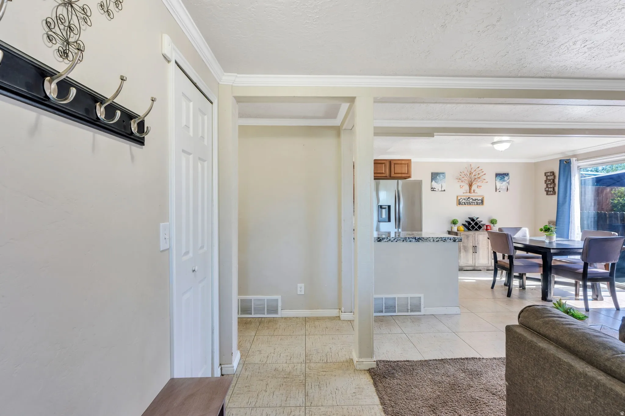 Open-concept living area with tile flooring and a kitchen island featuring a stone-look countertop