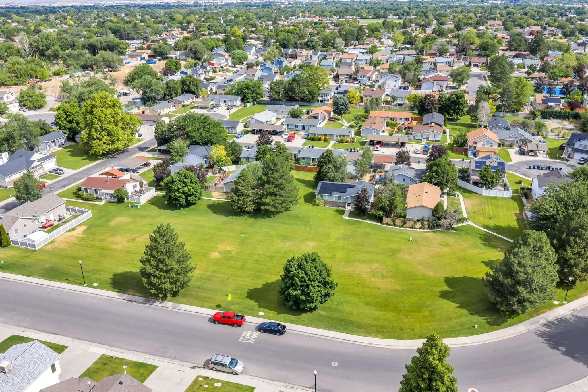 Aerial perspective showcasing a residential neighborhood with numerous single-family homes, mature trees, and green spaces