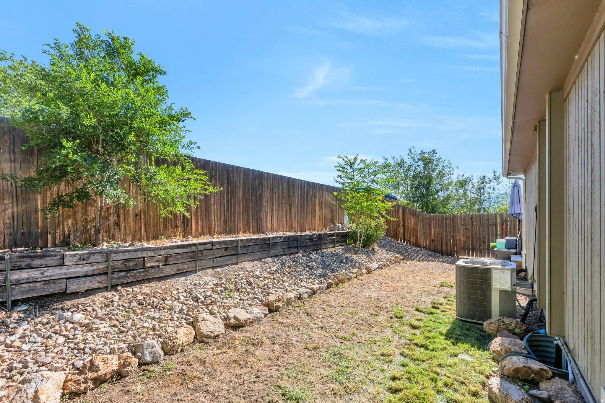 Private backyard featuring a full wood privacy fence and a tiered landscaping design