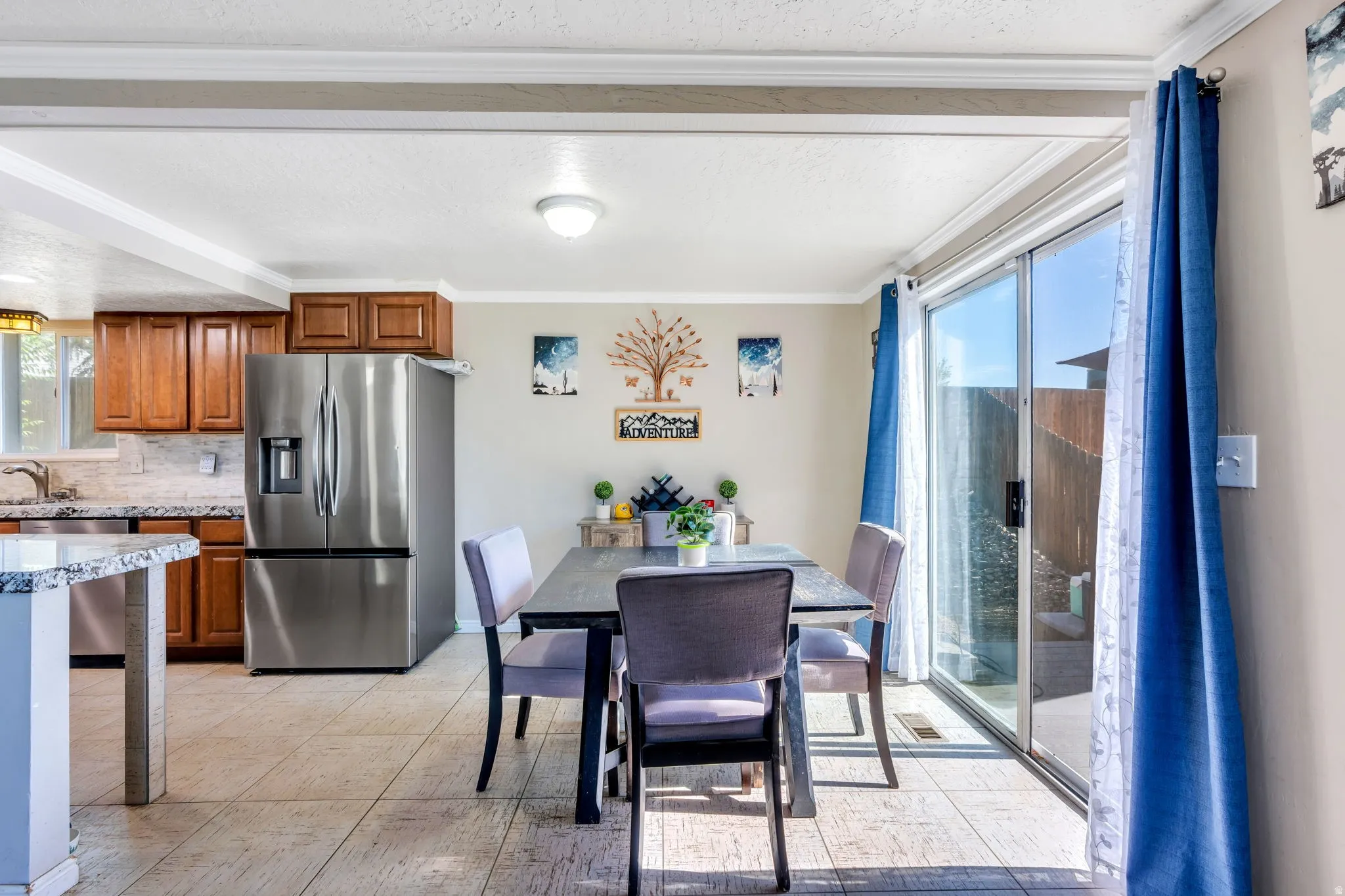 Dining area featuring a sliding glass door to the exterior, tile flooring, and crown molding