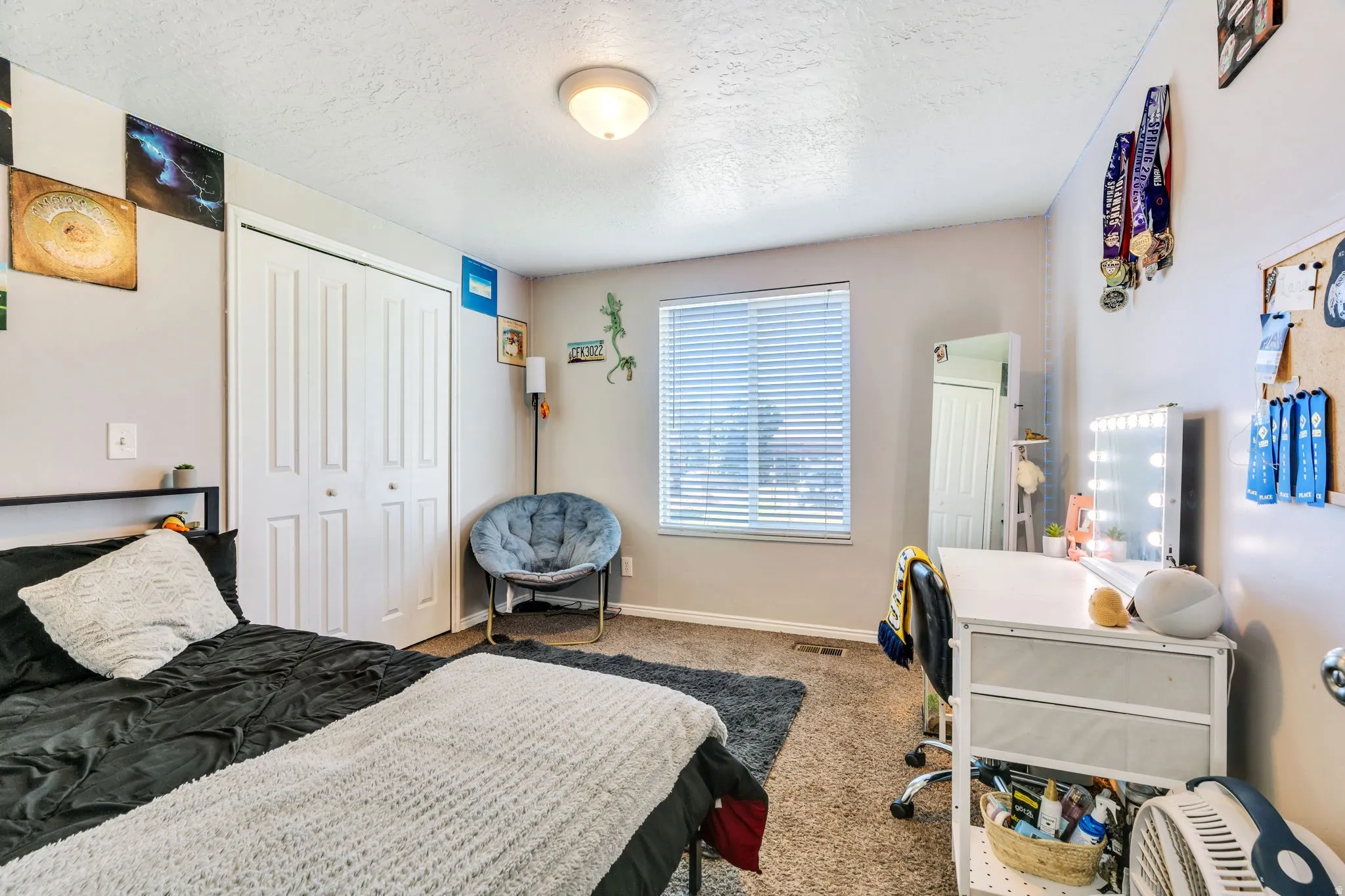 Recessed window with horizontal blinds, neutral wall paint, textured carpet flooring, and a flush-mount ceiling light fixture