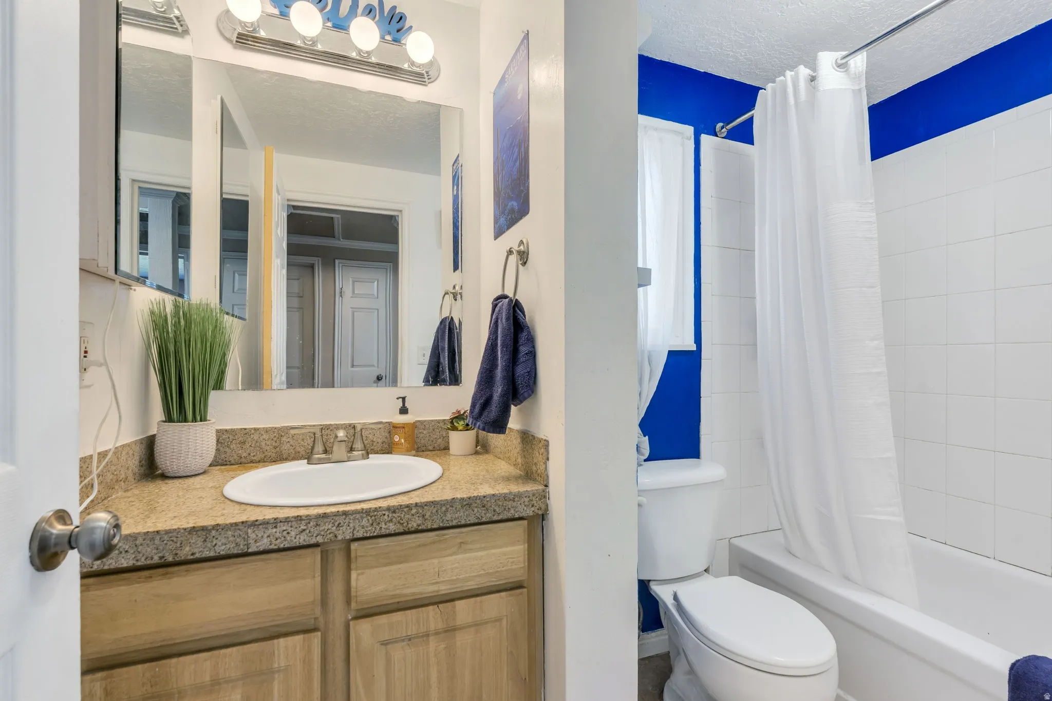 Bathroom featuring a vanity with a light-toned countertop, an undermount sink, and wood-finish cabinetry