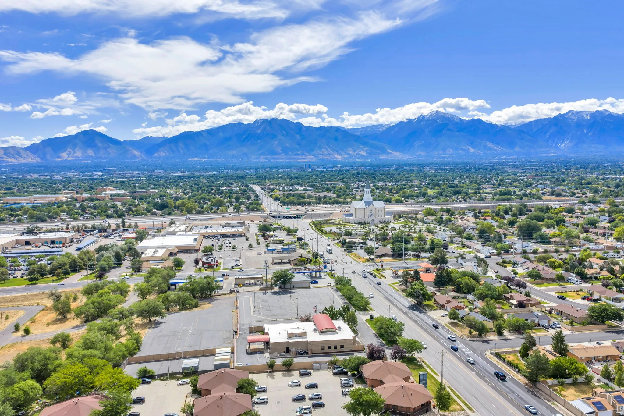 Expansive aerial perspective showcasing a broad urban landscape with distant mountain ranges