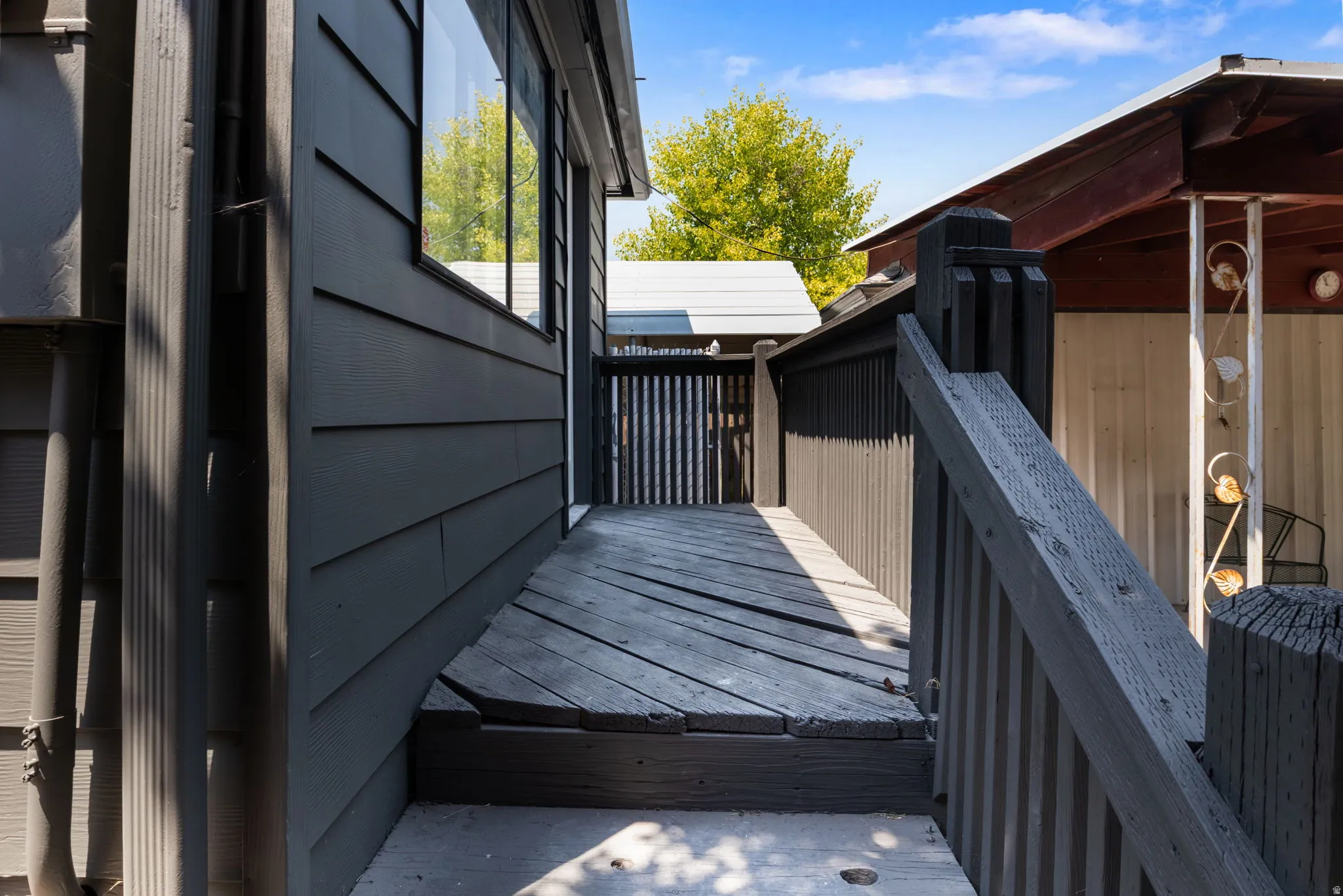 Rear Deck & Entrance to Mudroom / Laundry exterior featuring dark gray horizontal siding and a dark wood-finish deck