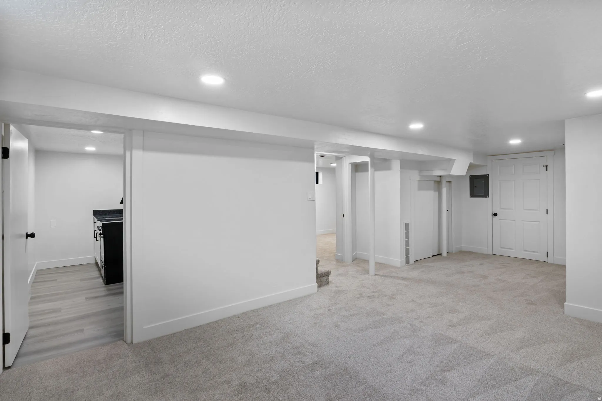 Spacious lower-level area with plush gray carpeting and recessed lighting