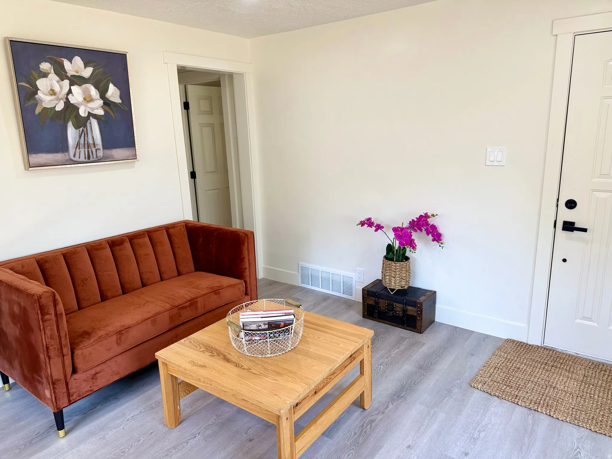 Entryway featuring light wood-finish flooring, white baseboards, and a white paneled door with matte black hardware