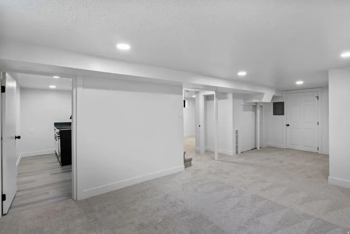 Spacious lower-level area with plush gray carpeting and recessed lighting