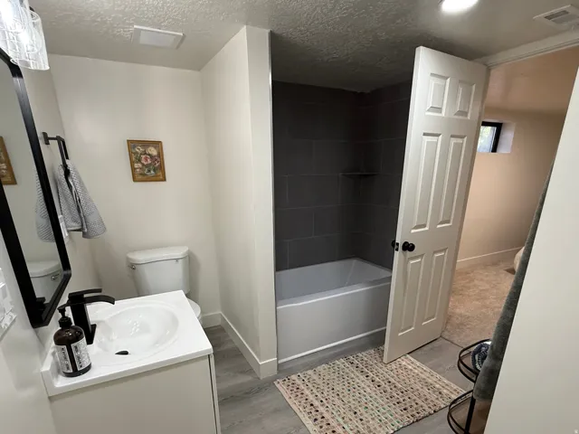 Bathroom featuring a white vanity with an integrated sink, matte black faucet, and a large wall-mounted mirror