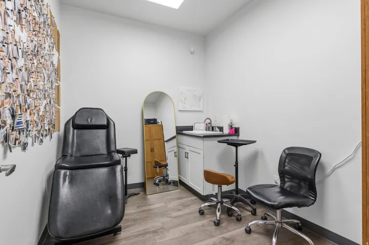 Room featuring light wood-finish flooring, white walls, and a built-in vanity with a sink