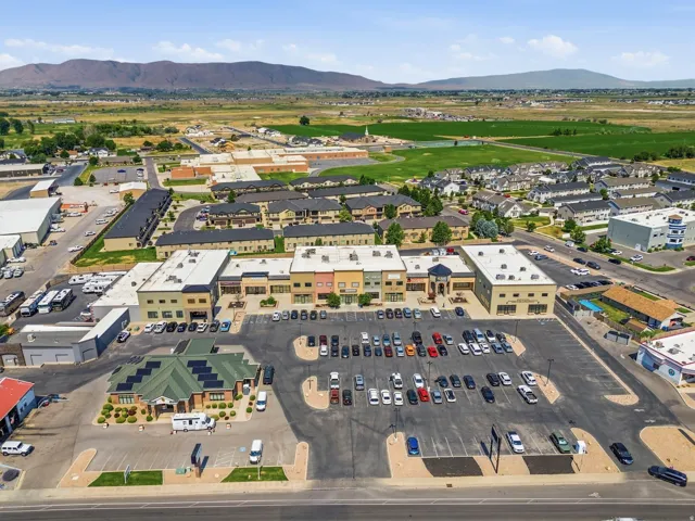 Expansive commercial property featuring multiple single-story buildings with varied facades, a large paved parking area, and mature landscaping