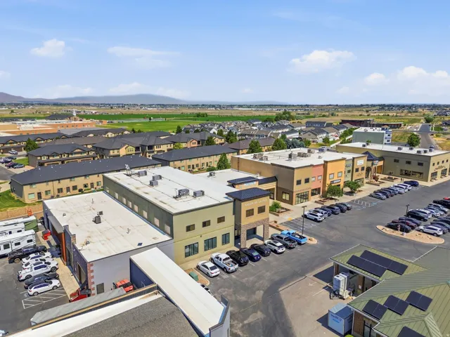 Expansive commercial complex featuring multiple buildings with varied facades, ample on-site parking, and rooftop solar panels