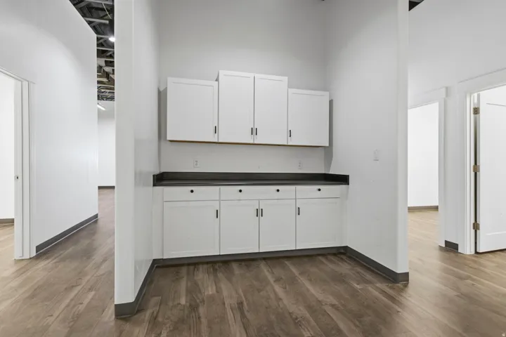 Built-in cabinetry with white shaker-style doors and dark countertops