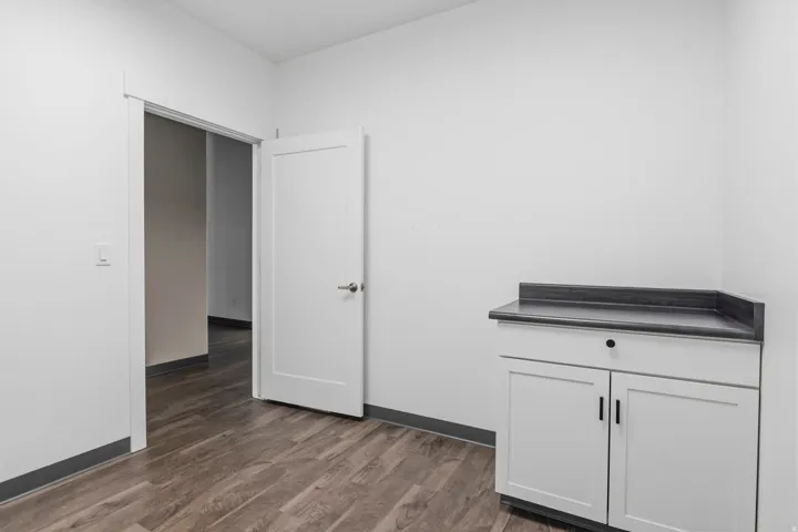 White shaker-style cabinetry with a single drawer and matte black pulls