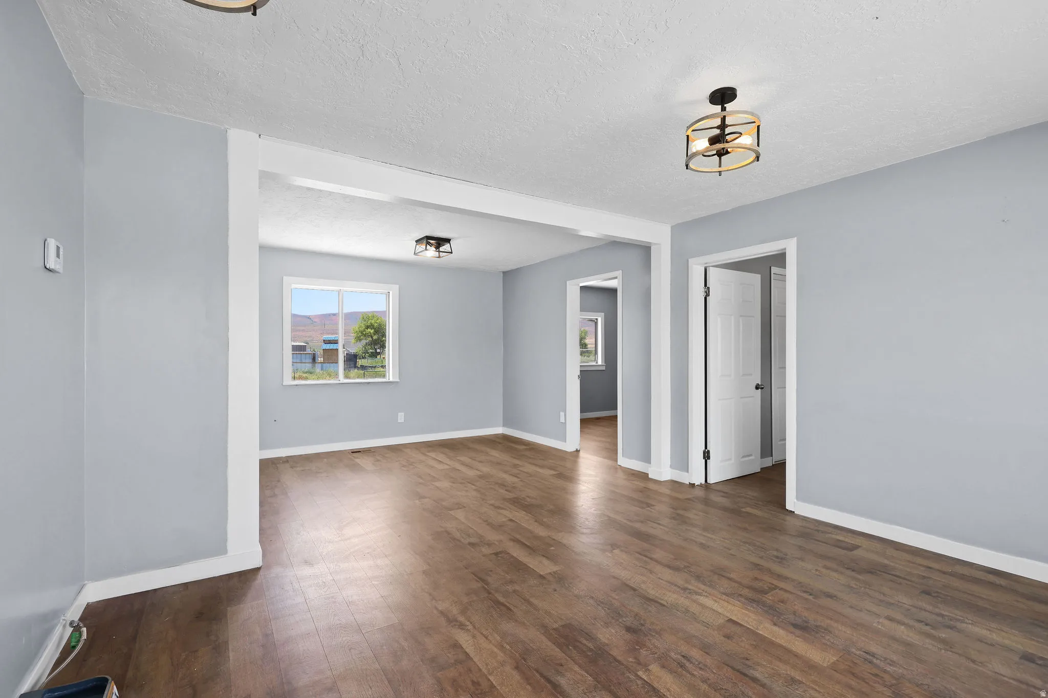 Open concept living space featuring wood-finish flooring, light gray walls, and white trim